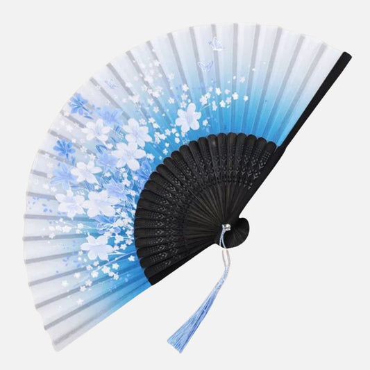 Éventail en papier avec dégradé bleu et motifs floraux blancs, monture noire et pompon bleu