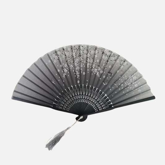 Éventail noir et gris avec motifs floraux, en bois, ouvert et décoratif sur fond blanc