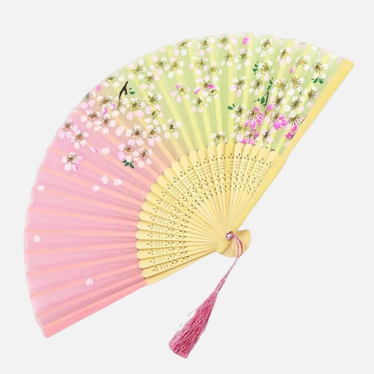 Éventail en papier aux couleurs pastel avec motifs de fleurs, décoré d'une frange rose et monté sur une armature en