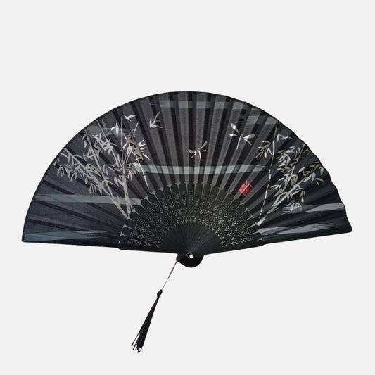 Éventail noir avec des motifs de bambou et des libellules, décoré d'un pompon en fil noir