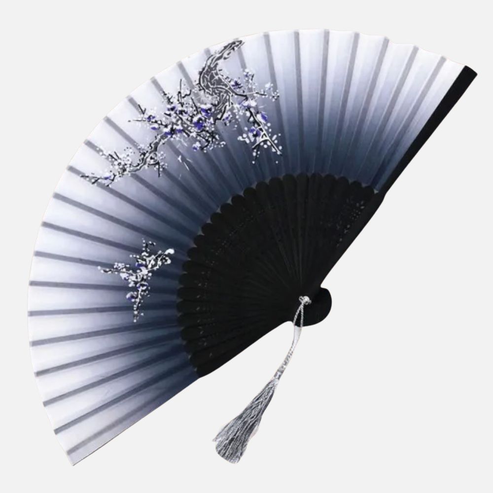 Éventail en dégradé de gris et noir, orné de motifs floraux en argent et violet, avec un pompon en fil