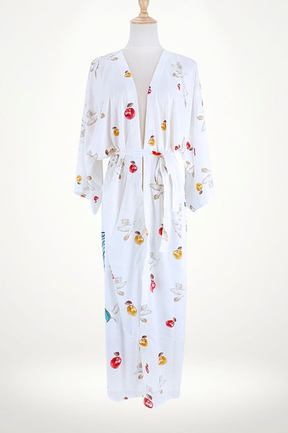 Kimono blanc avec motifs de pommes rouges et dorées, manches larges et ceinture assortie, sur fond neutre