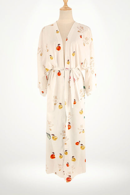 Kimono en satin blanc avec motifs de fruits colorés et oiseaux, ceinturé à la taille, sur fond neutre