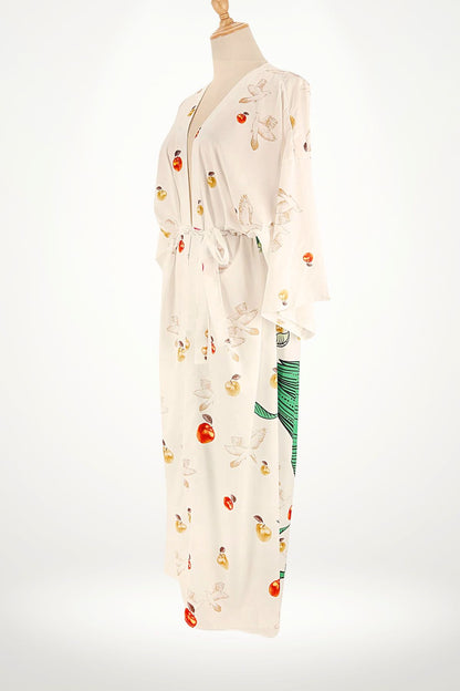 Kimono en satin blanc avec motifs de fruits colorés et oiseaux, drapé élégamment sur un mannequin