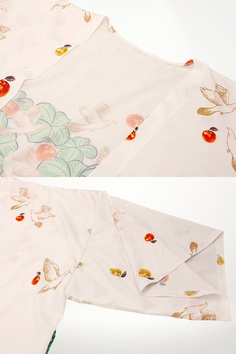Kimono en satin léger avec motifs de oiseaux et fruits colorés sur fond blanc, évoquant un jardin imaginaire