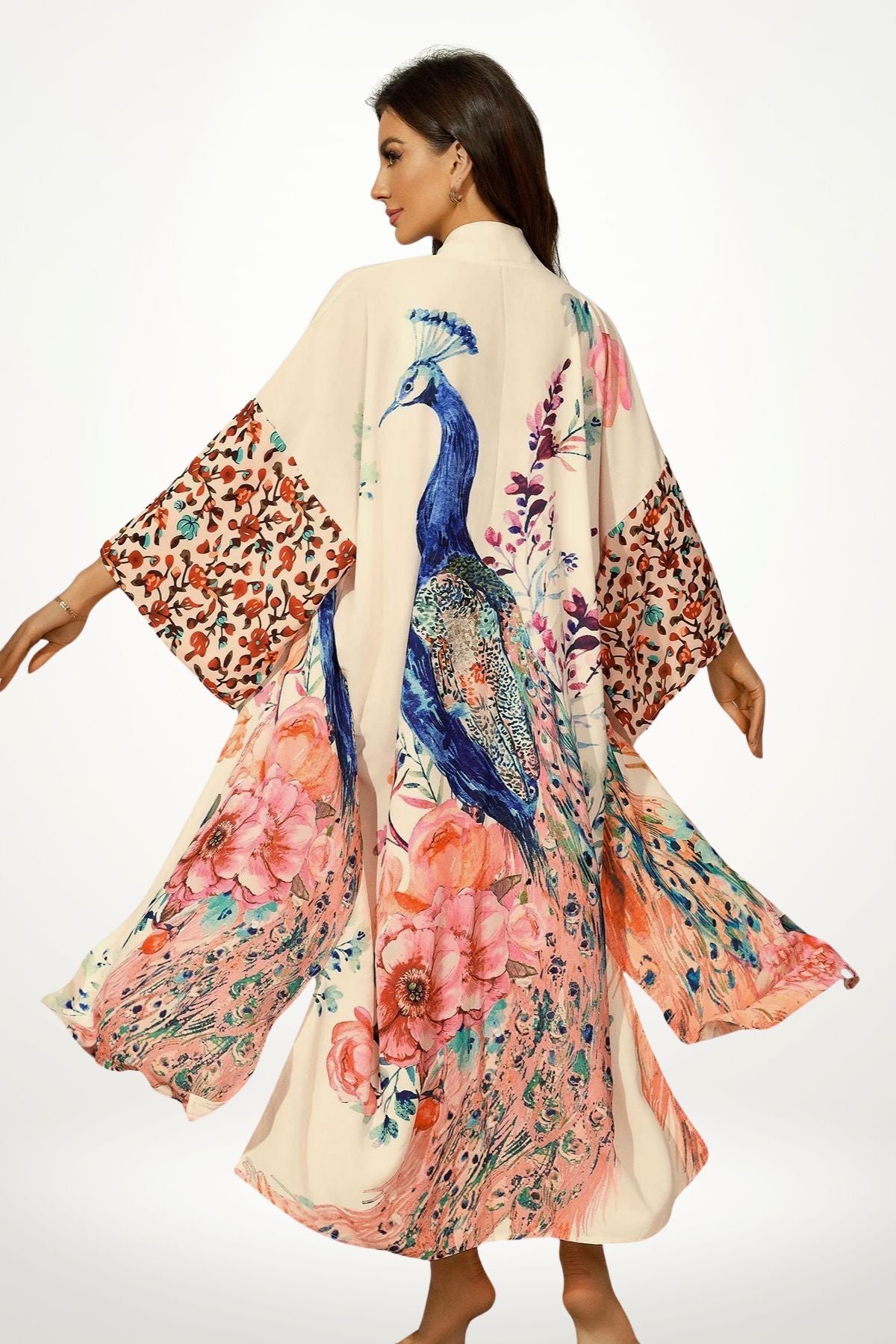 Femme portant un kimono en satin beige avec motifs floraux colorés et un paon, dans une posture élégante