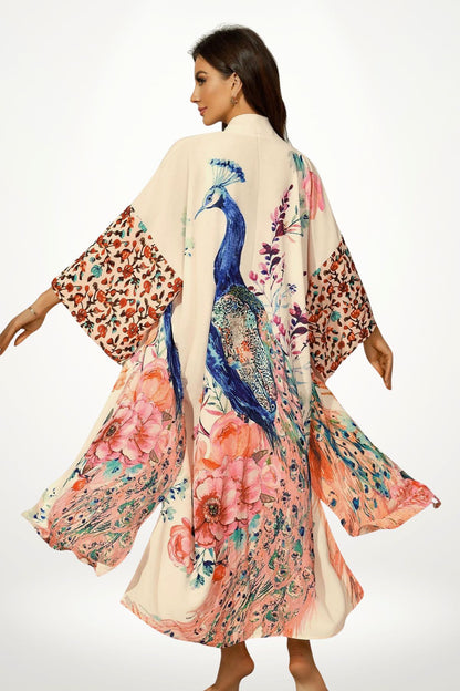 Femme portant un kimono en satin beige avec motifs floraux colorés et un paon, dans une posture élégante