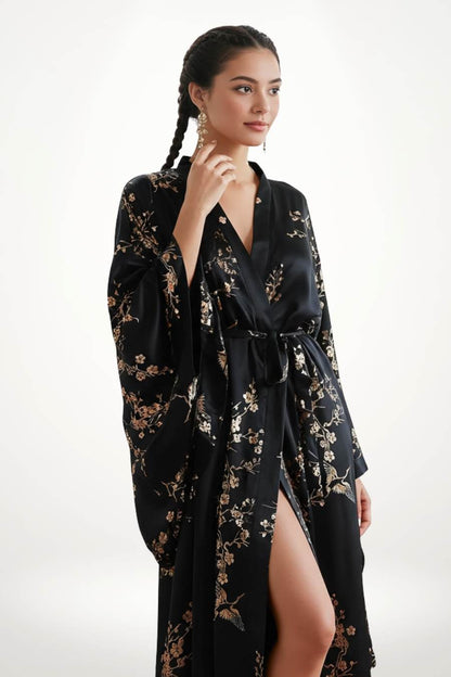 Kimono long noir avec motifs floraux dorés, manches larges et ceinture, sur fond neutre