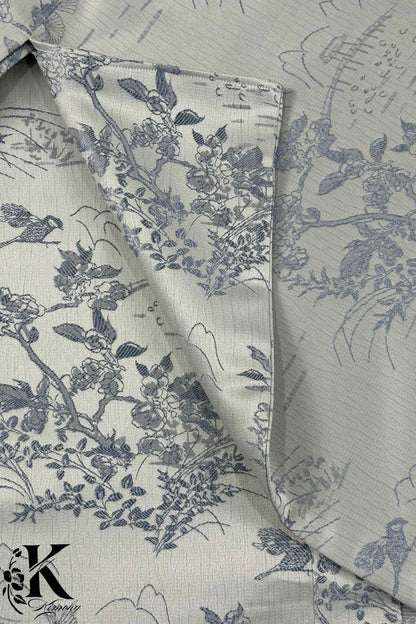 Tissu de kimono gris clair avec motifs floraux et oiseaux en bleu, texture légèrement plissée et élégante