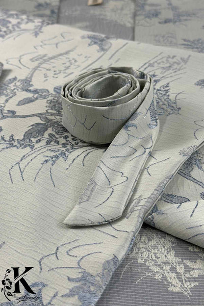 Tissu de kimono en nuances de gris et bleu, avec motifs floraux délicats et ceinture roulée en satin