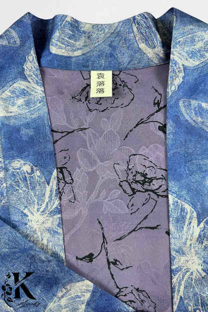Détail d'un kimono féminin en bleu avec motifs floraux sur fond violet, tissu léger et élégant