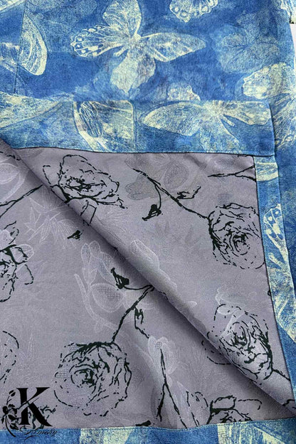 Un kimono en tissu bleu avec des motifs de papillons et un intérieur gris orné de fleurs noires