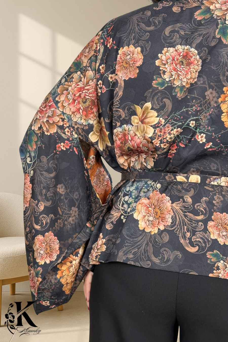 Kimono noir à fleurs colorées, manches larges, porté dans un décor de jardin obscur, style japonais élégant