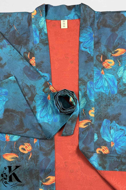 Kimono femme chic avec des motifs floraux bleus sur fond noir et une doublure orange éclatante