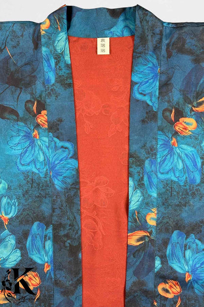 Kimono élégant avec motifs floraux bleus et orange sur fond noir, doublure rouge unie visible au centre