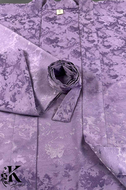 Veste kimono femme en tissu violet avec des motifs floraux subtils, élégamment pliée sur un fond neutre