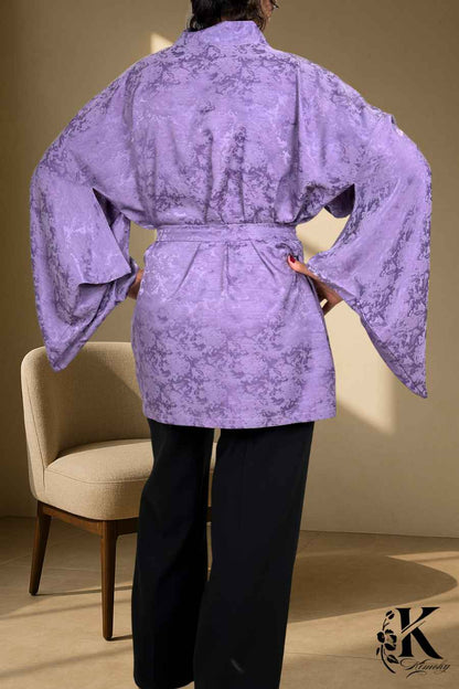 Veste kimono femme en satin violet avec motifs floraux, manches larges, portée sur un pantalon noir
