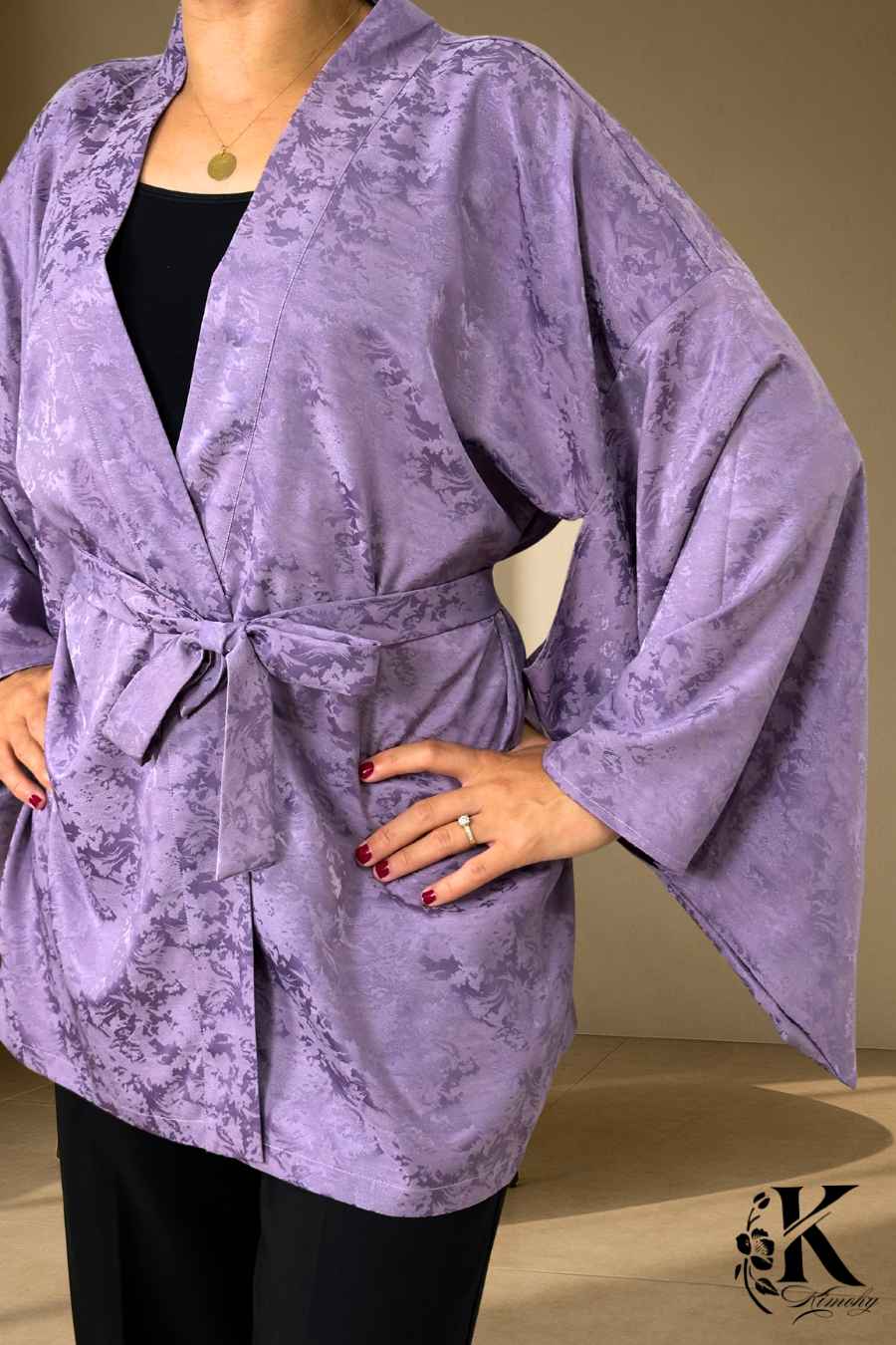 Veste kimono femme en satin violet avec motifs floraux subtils, portée avec un pantalon noir élégant