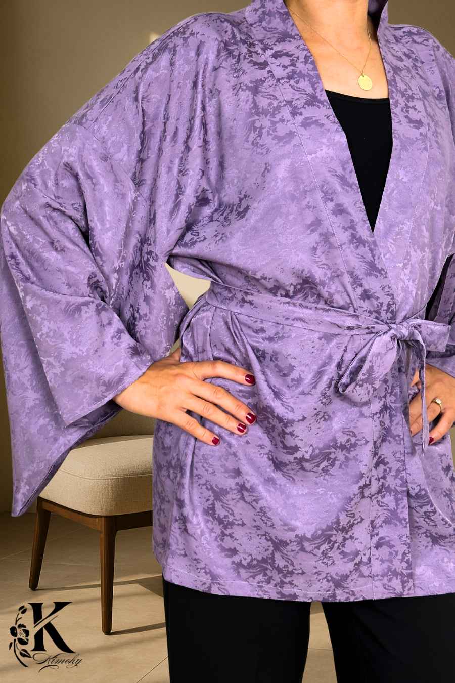 Veste kimono femme en tissu violet avec motifs subtils, ceinture nouée et manches larges, sur fond clair