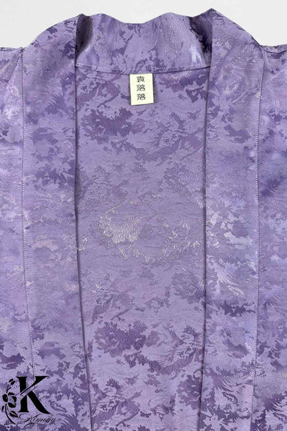 Veste kimono en satin violet avec un motif floral subtil, présentant une texture lisse et brillante