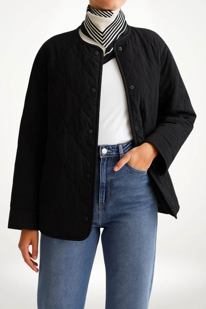 Mannequin portant une veste kimono femme matelassée noire en polyester avec quilting circulaire, coupe droite et col rond.