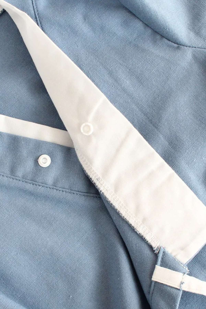 Détail d'un kimono bleu en tissu léger avec des boutons blancs et des finitions soignées