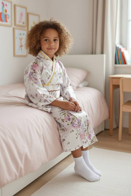 Fille en kimono blanc à motifs floraux, tenant un éventail rouge, assise sur son lit