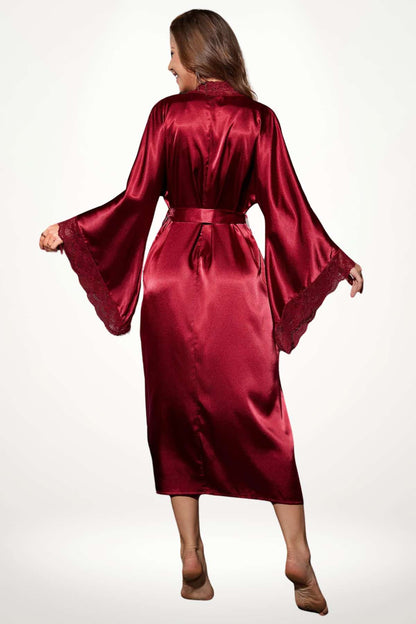 Femme portant un kimono rouge en satin, avec des manches évasées et une ceinture, sur fond neutre