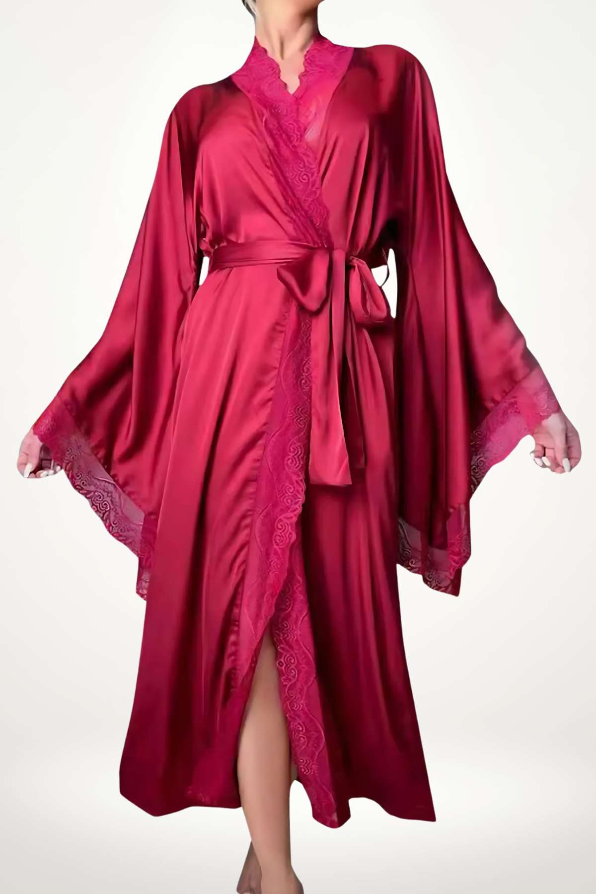 Femme en kimono rouge satiné avec des manches larges, dentelle rose, posée sur un fond clair