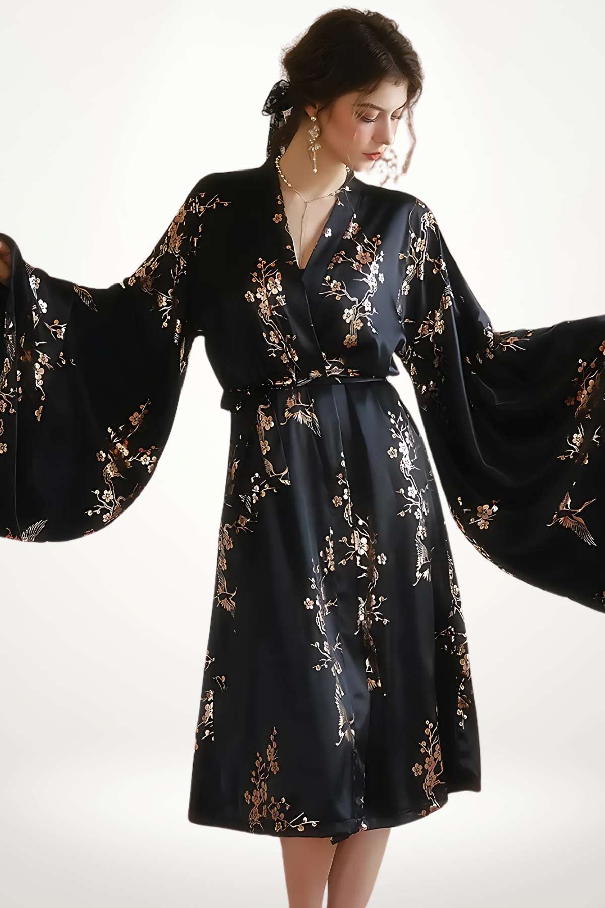 Kimono long noir avec motifs floraux dorés, manches larges et ceinture, sur fond neutre
