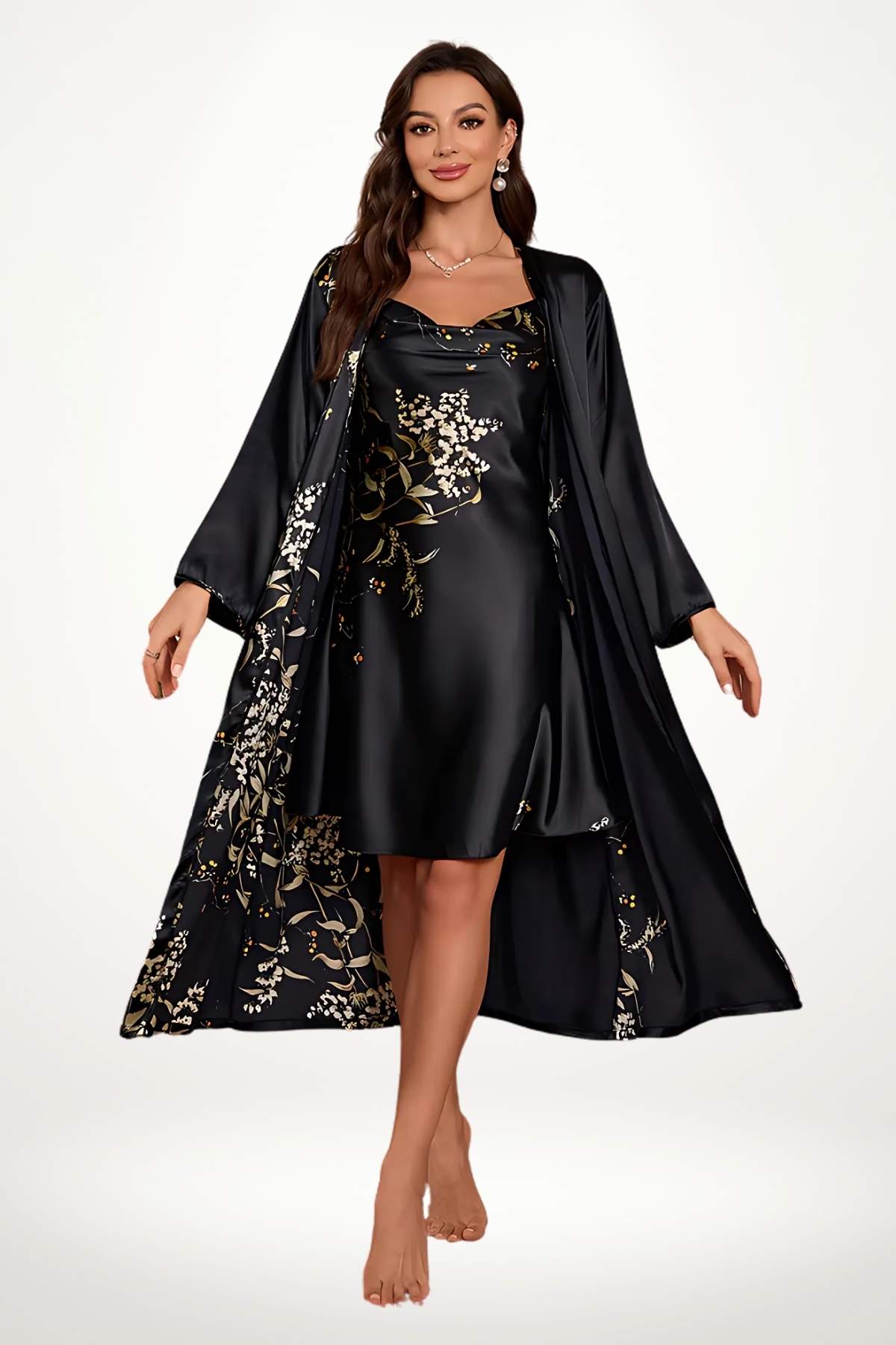Femme en peignoir noir satiné avec motifs floraux dorés, posant élégamment sur un fond clair