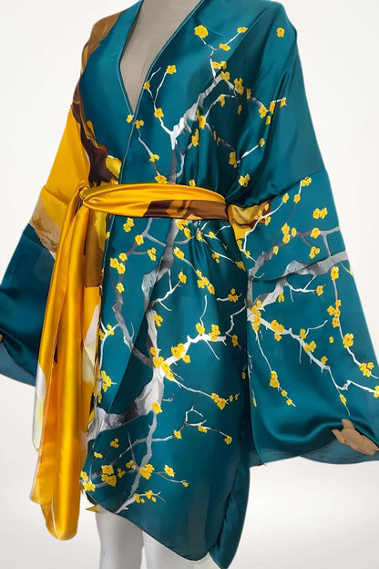 Kimono en satin bleu-vert avec motifs floraux jaunes et ceinture satinée dorée, posé sur un mannequin