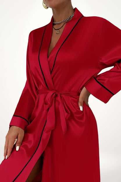 Kimono en satin rouge vif avec des détails noirs, porté avec une ceinture nouée et une posture élégante