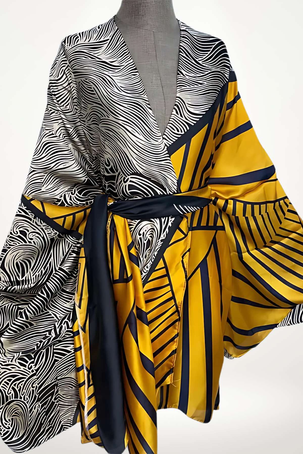 Kimono en satin aux motifs noirs et jaunes, avec des rayures et des formes géométriques, drapé élégamment
