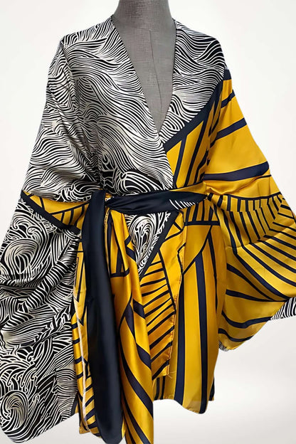 Kimono en satin aux motifs noirs et jaunes, avec des rayures et des formes géométriques, drapé élégamment