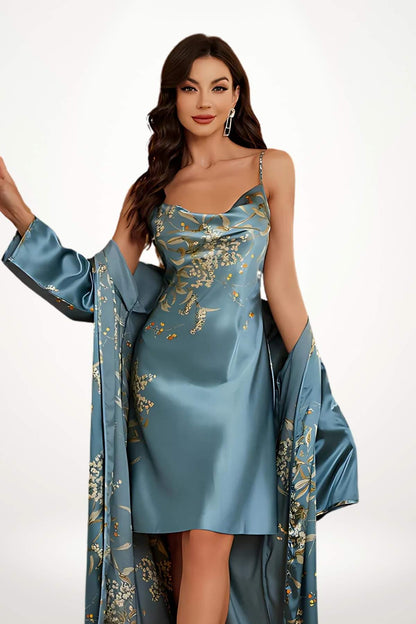 Femme en kimono bleu satin, décoré de motifs floraux dorés, posant avec élégance sur fond clair