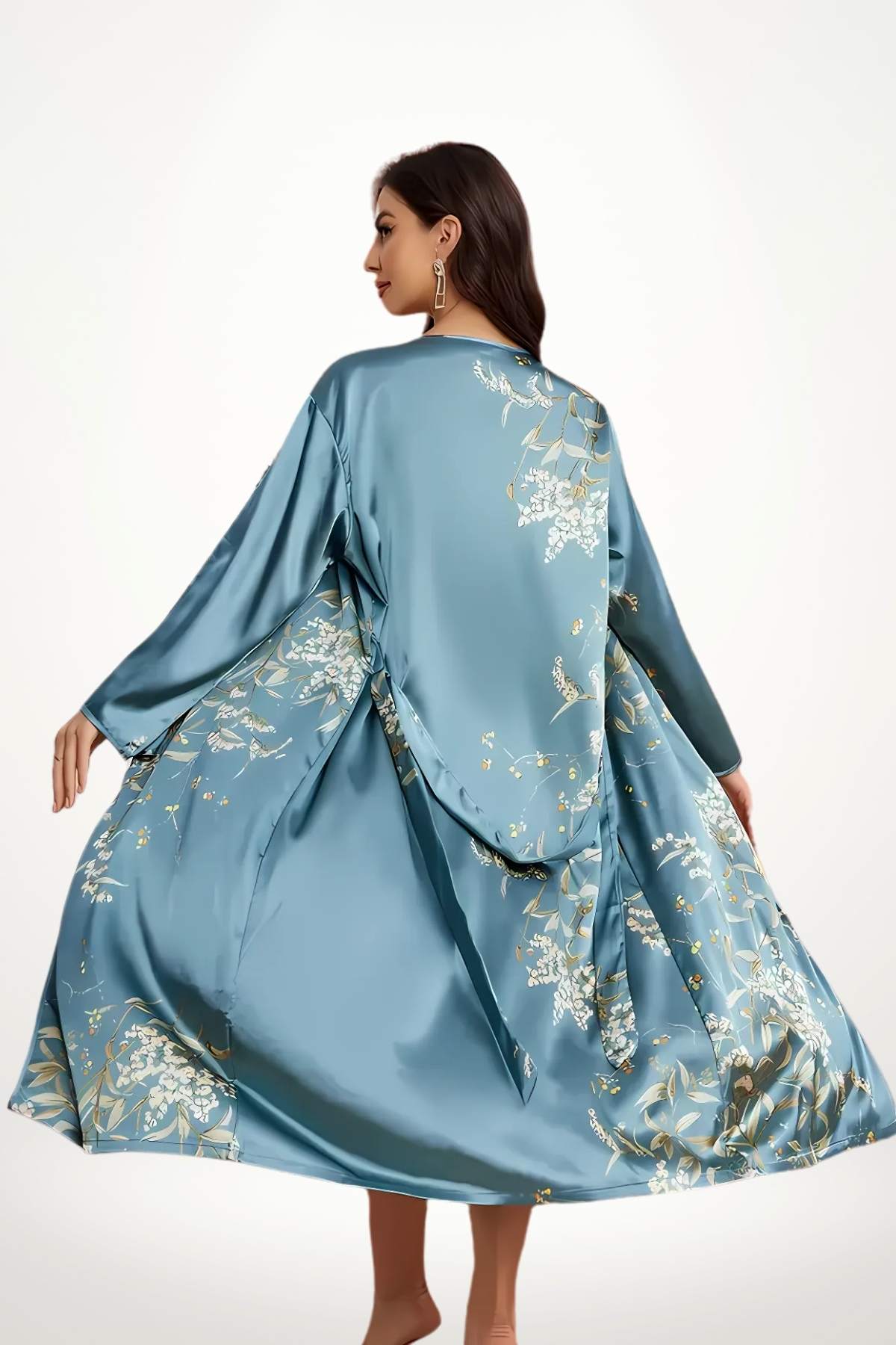 Kimono en satin bleu orné de motifs floraux, porté de manière fluide, avec une posture gracieuse et élégante