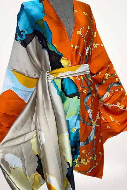 Kimono en satin aux couleurs vives orange et bleu, avec des motifs floraux délicats et une ceinture grise