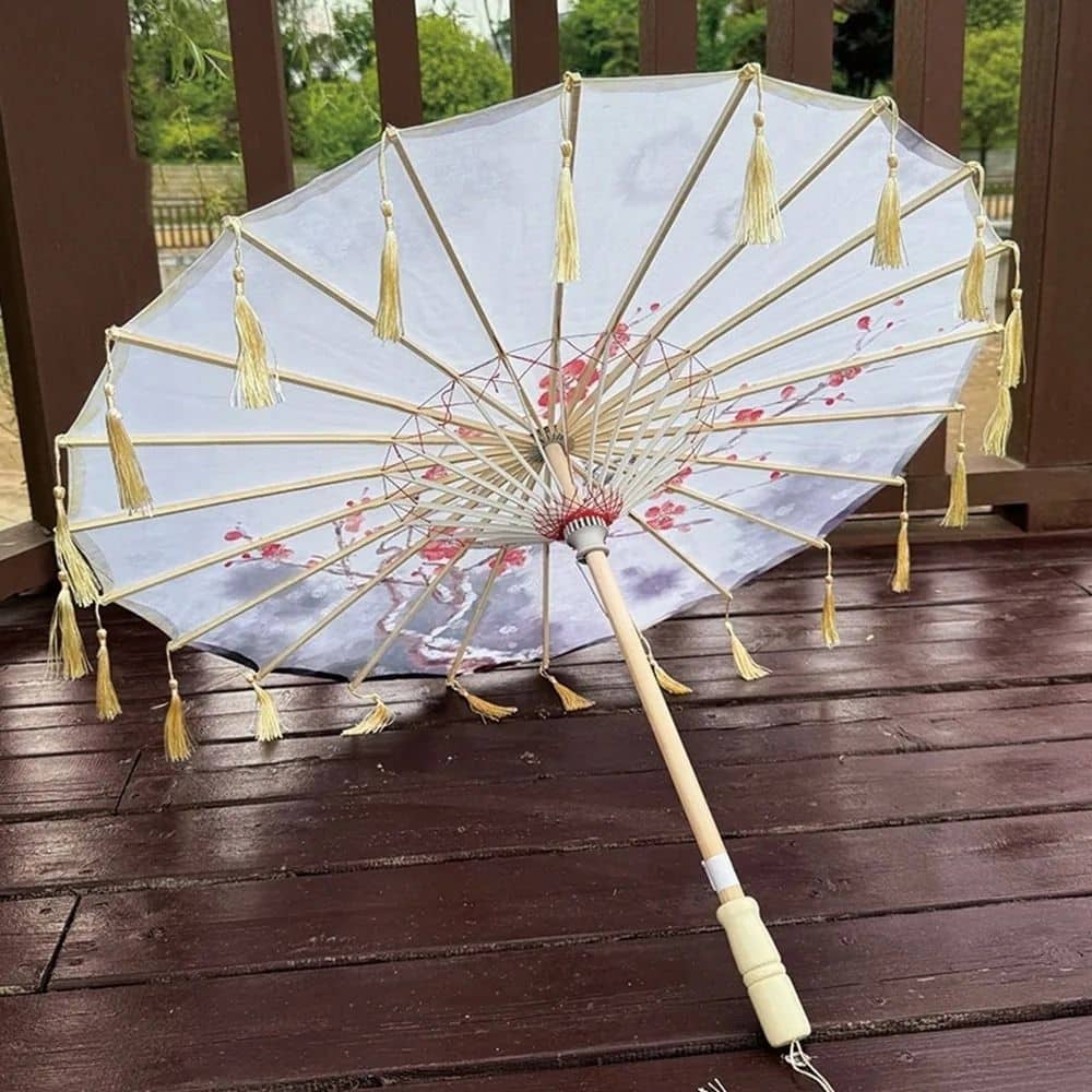 Ombrelle anti-UV blanche ornée de motifs floraux, avec des franges dorées et une structure en bois