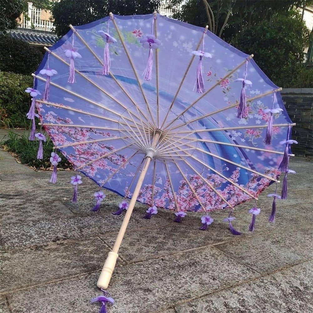 Ombrelle pliable violette ornée de fleurs, avec des franges violettes et un décor floral sur le tissu