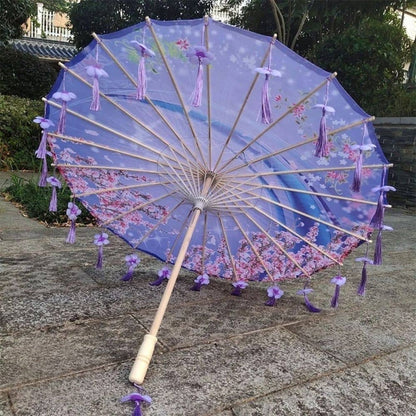Ombrelle pliable violette ornée de fleurs, avec des franges violettes et un décor floral sur le tissu