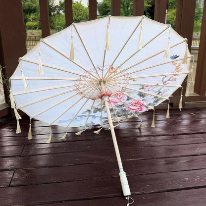Ombrelle anti-UV blanche avec des motifs floraux colorés, posée sur un sol en bois foncé
