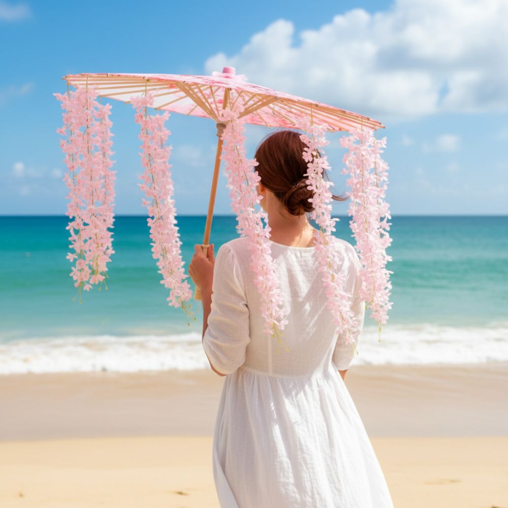 Femme portant une ombrelle fleurie rose, se tenant sur une plage avec mer turquoise et ciel bleu