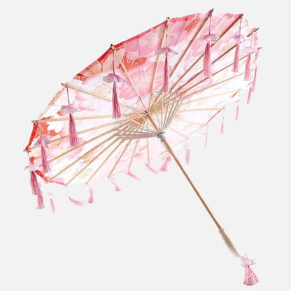 Ombrelle japonaise anti UV rose ornée de franges, avec un motif floral délicat et une structure en bois