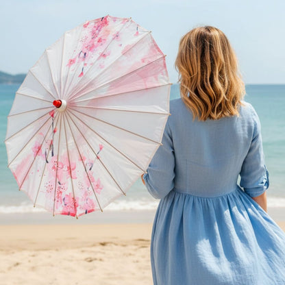 Ombrelle japonaise blanche avec motifs floraux roses, tenue en denim, vue sur la plage et la mer