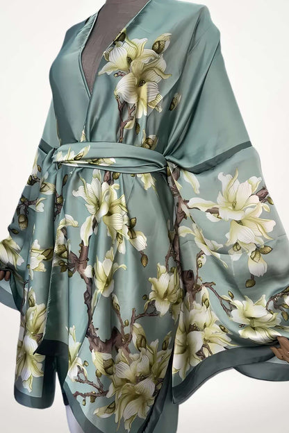 Robe kimono en satin vert avec motifs floraux blancs et bruns, drapée élégamment, ceinturée à la taille