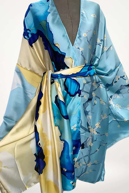 Robe kimono en satin bleu avec motifs floraux en jaune et bleu, drapée élégamment sur un mannequin