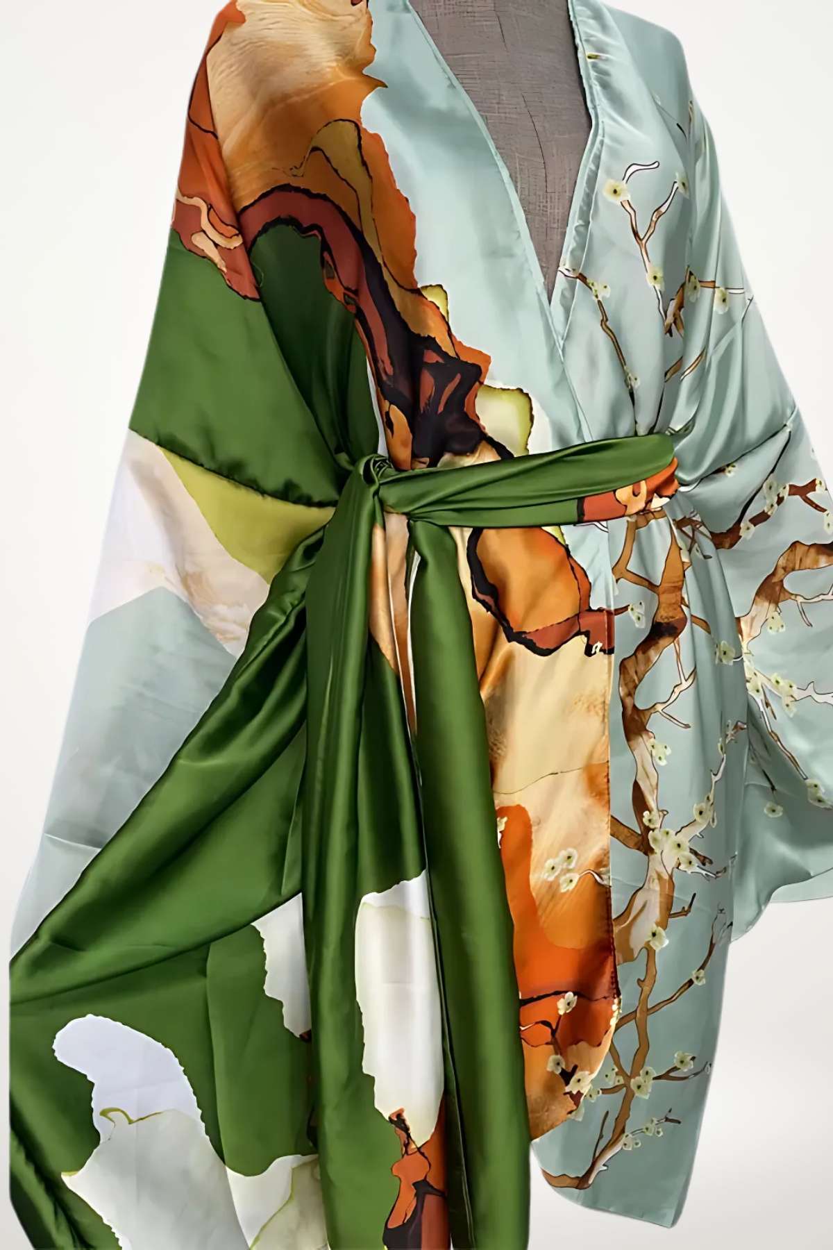 Robe kimono en satin bleu clair avec des motifs floraux orange et verts, ceinturée d'un sash vert