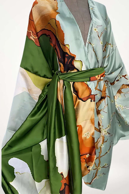Robe kimono en satin bleu clair avec des motifs floraux orange et verts, ceinturée d'un sash vert