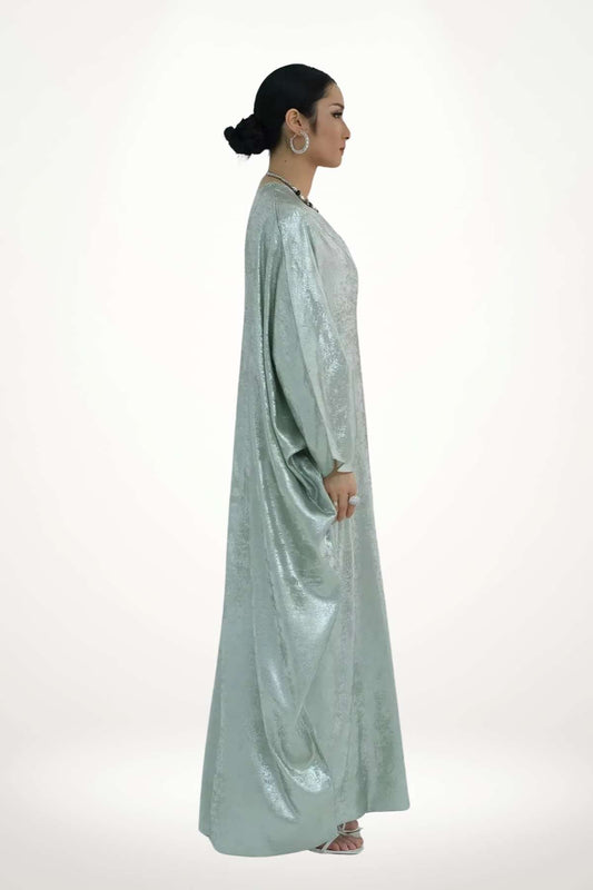Abaya kimono en satin texturé vert à l’éclat discret. Coupe fluide, design minimaliste et raffiné, idéale pour sublimer vos instants du quotidien ou vos occasions.